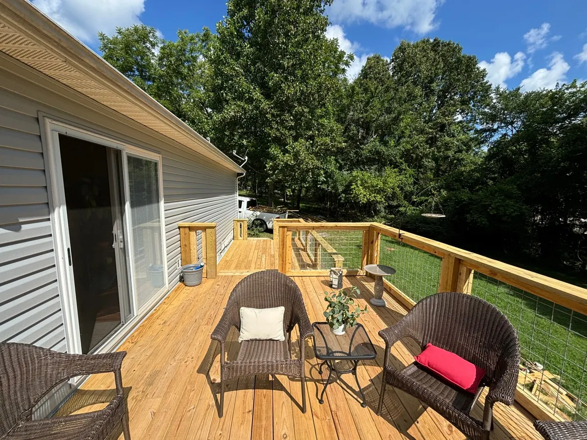 New pine deck with wire railings and patio chairs