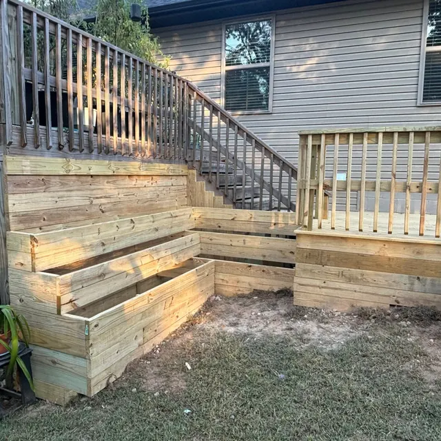 Tiered wood planters built into deck stairs